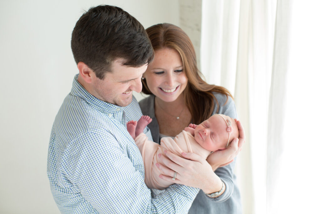 couple adoring their newborn smiling baby