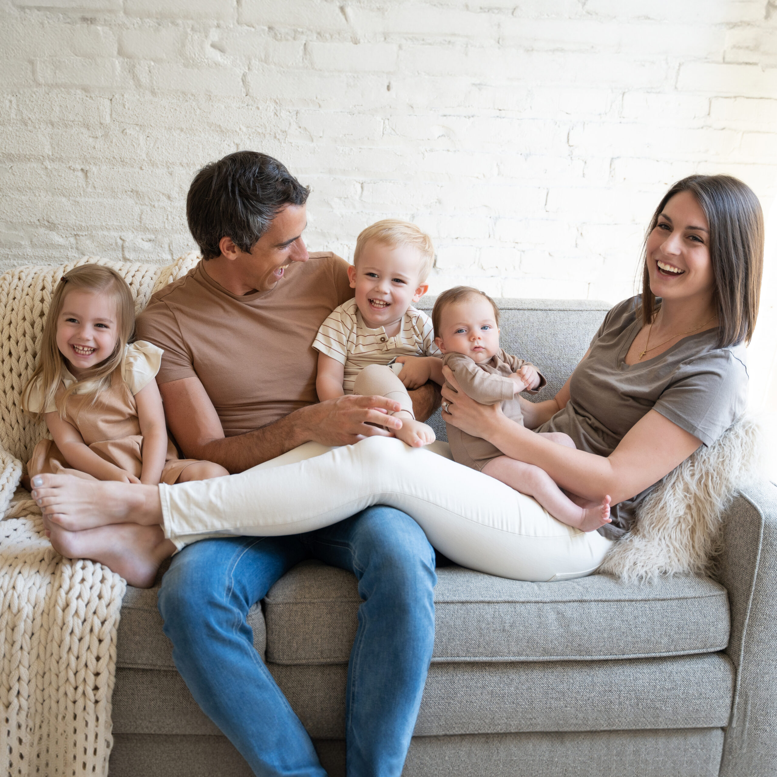 candid photo of family of five laughing on the couch