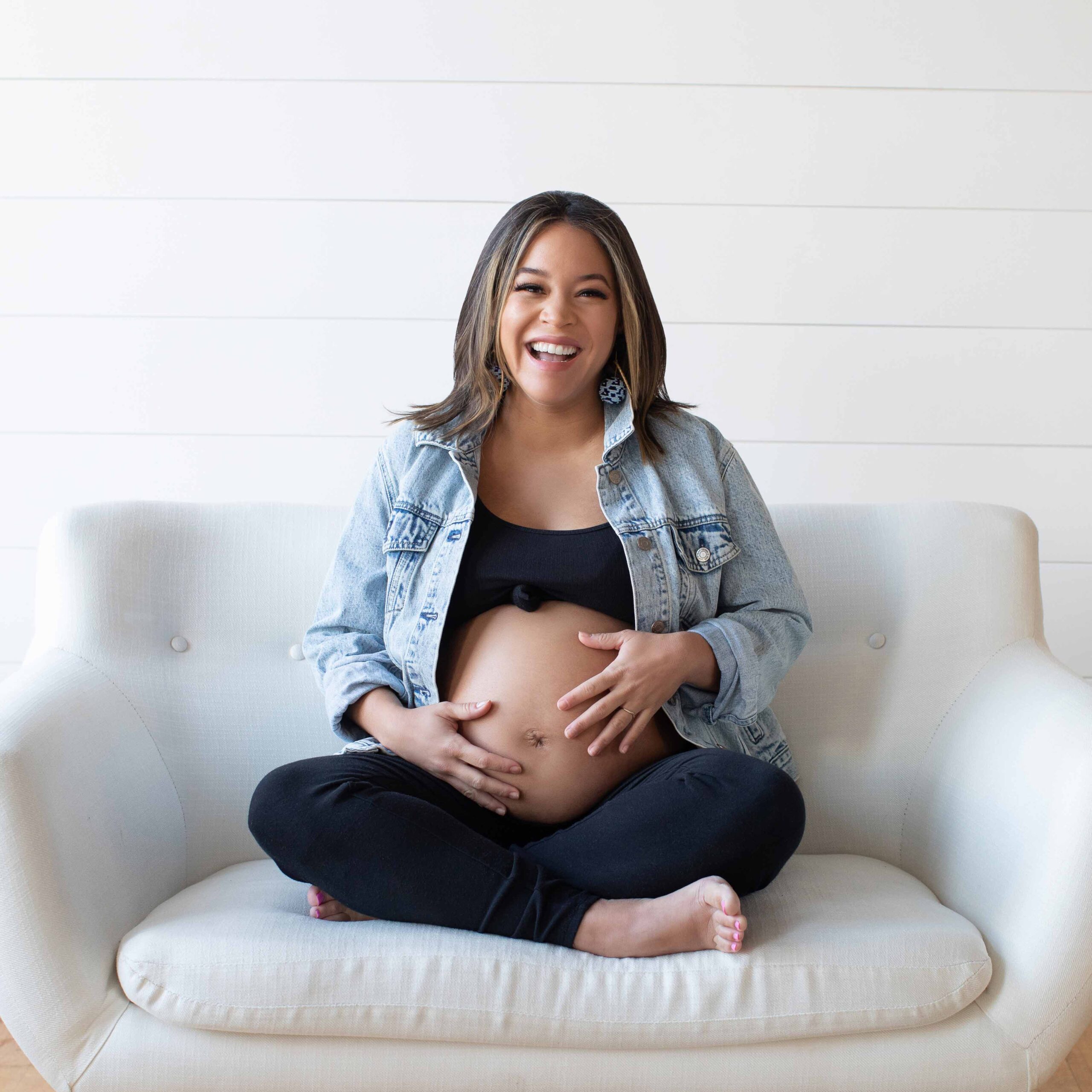 Pregnant woman holding belly, laughing
