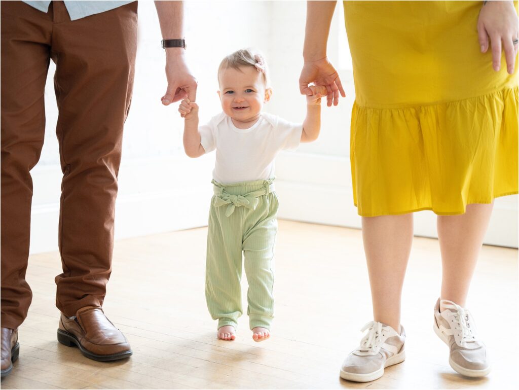 Family holding hands with little girl walking