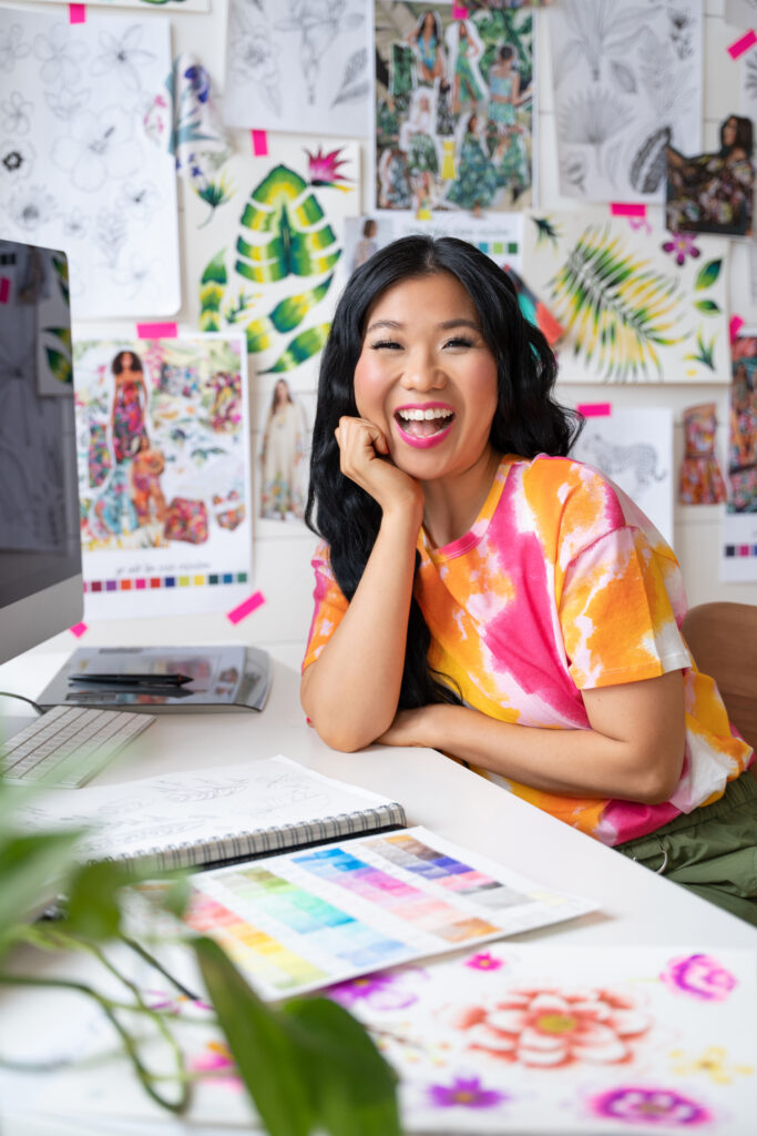 Creative professional sitting at desk with artwork all around her
