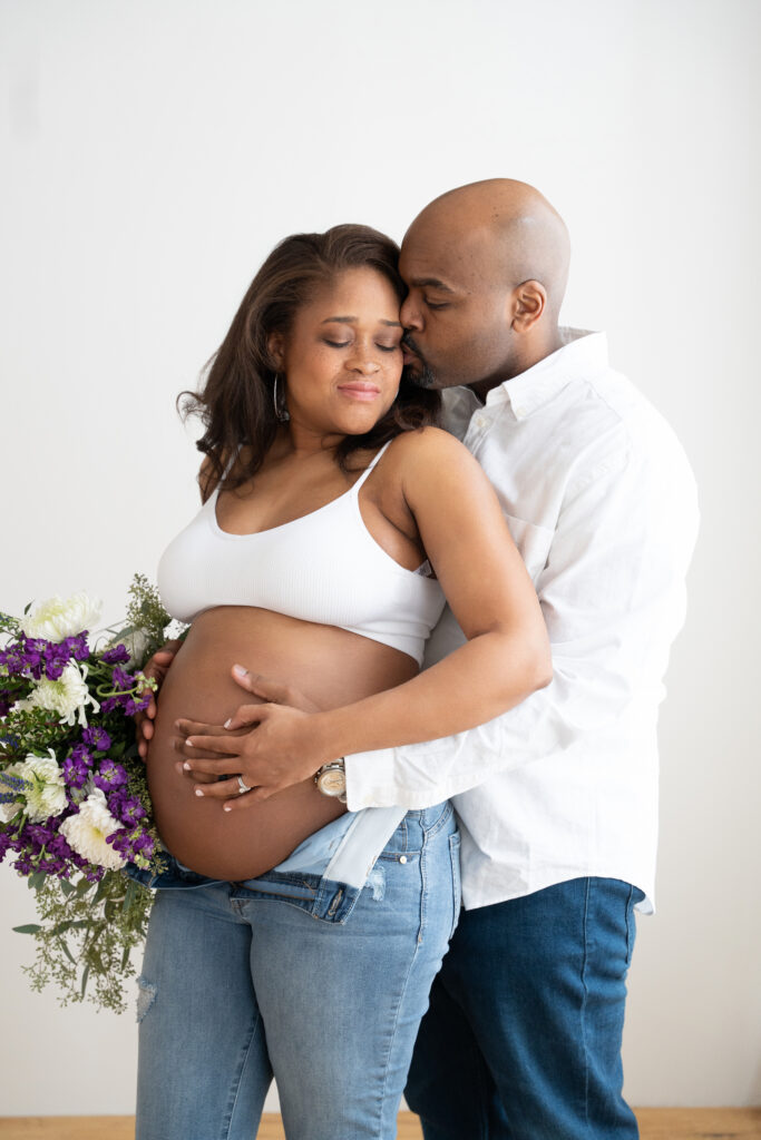 Maternity shoot, Husband huging wife from the back,botha re holding the belly.